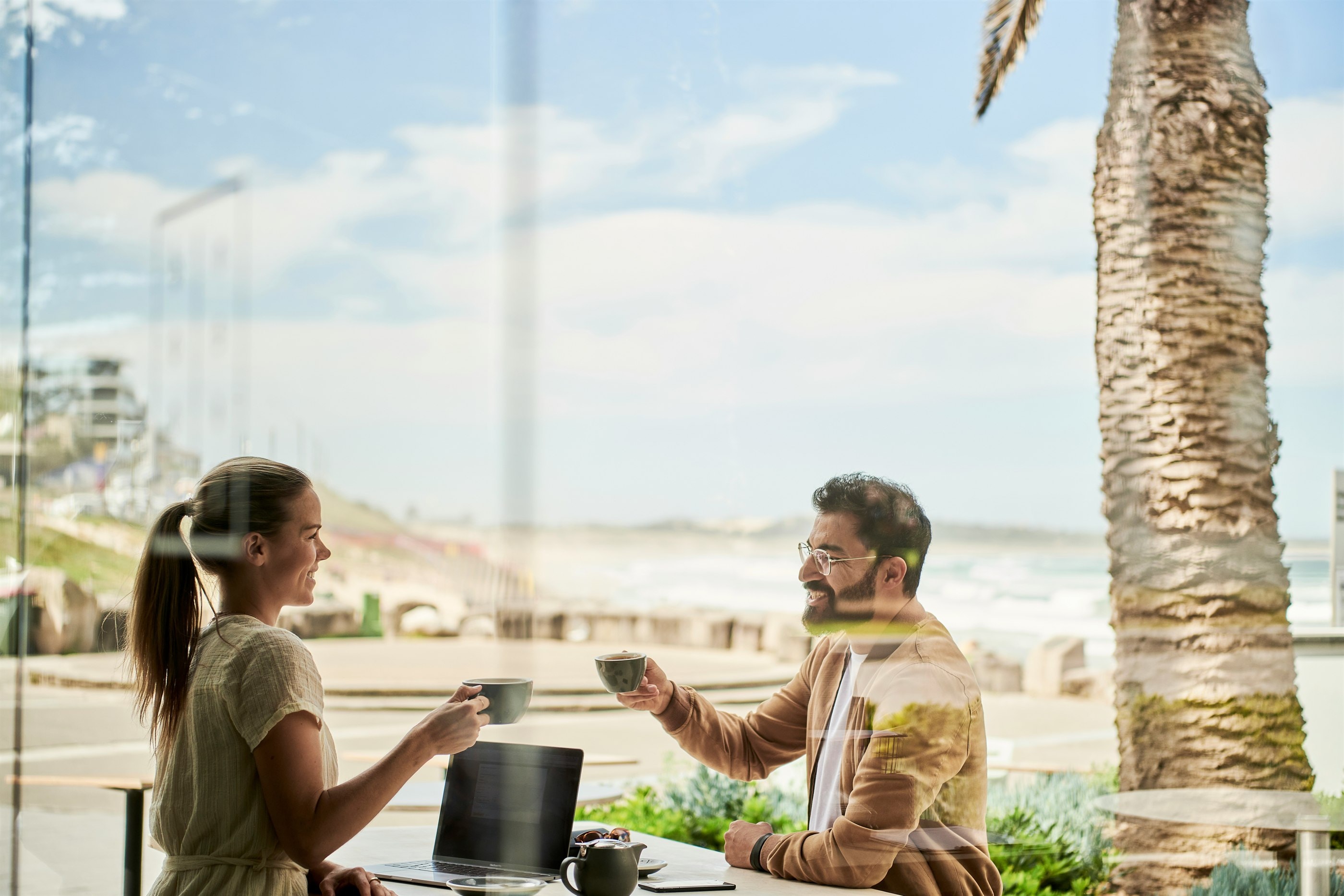 Two people sharing a relaxed conversation beside the coast